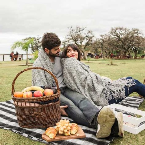 Namorados em um parque fazendo um piquenique.