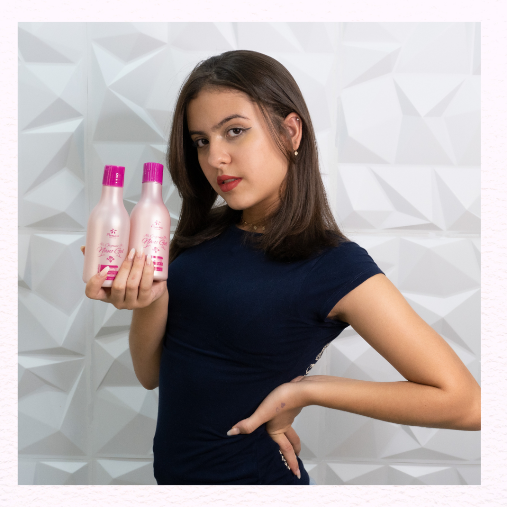 Uma mulher de cabelo escuro na altura dos ombros segurando o kit homecare organic nano gel, que contem óleo de rosa mosqueta